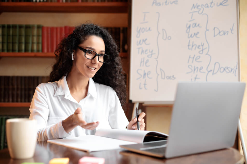 Lady Sitting At Table Using Computer For Video Call